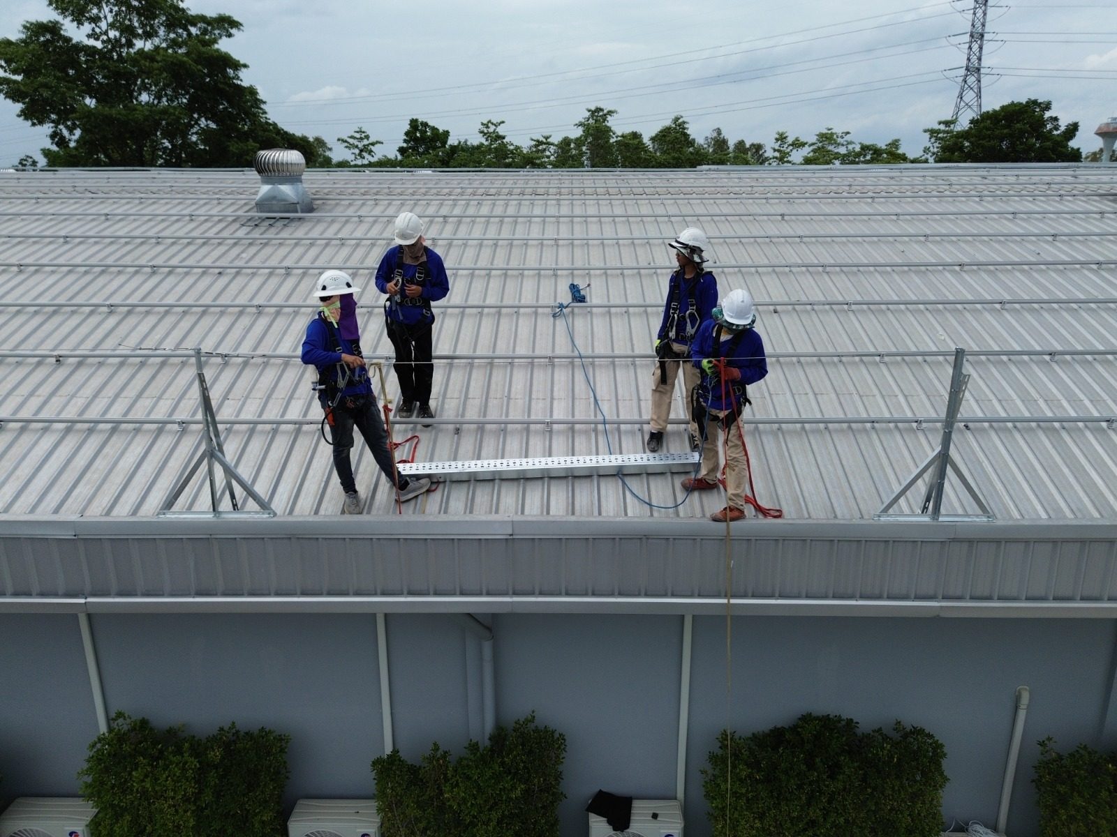 Technicians installing solar mounting rails on the factory roof