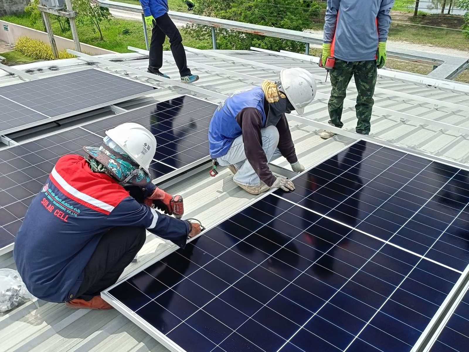Technicians securing a solar panel into place on the factory roof