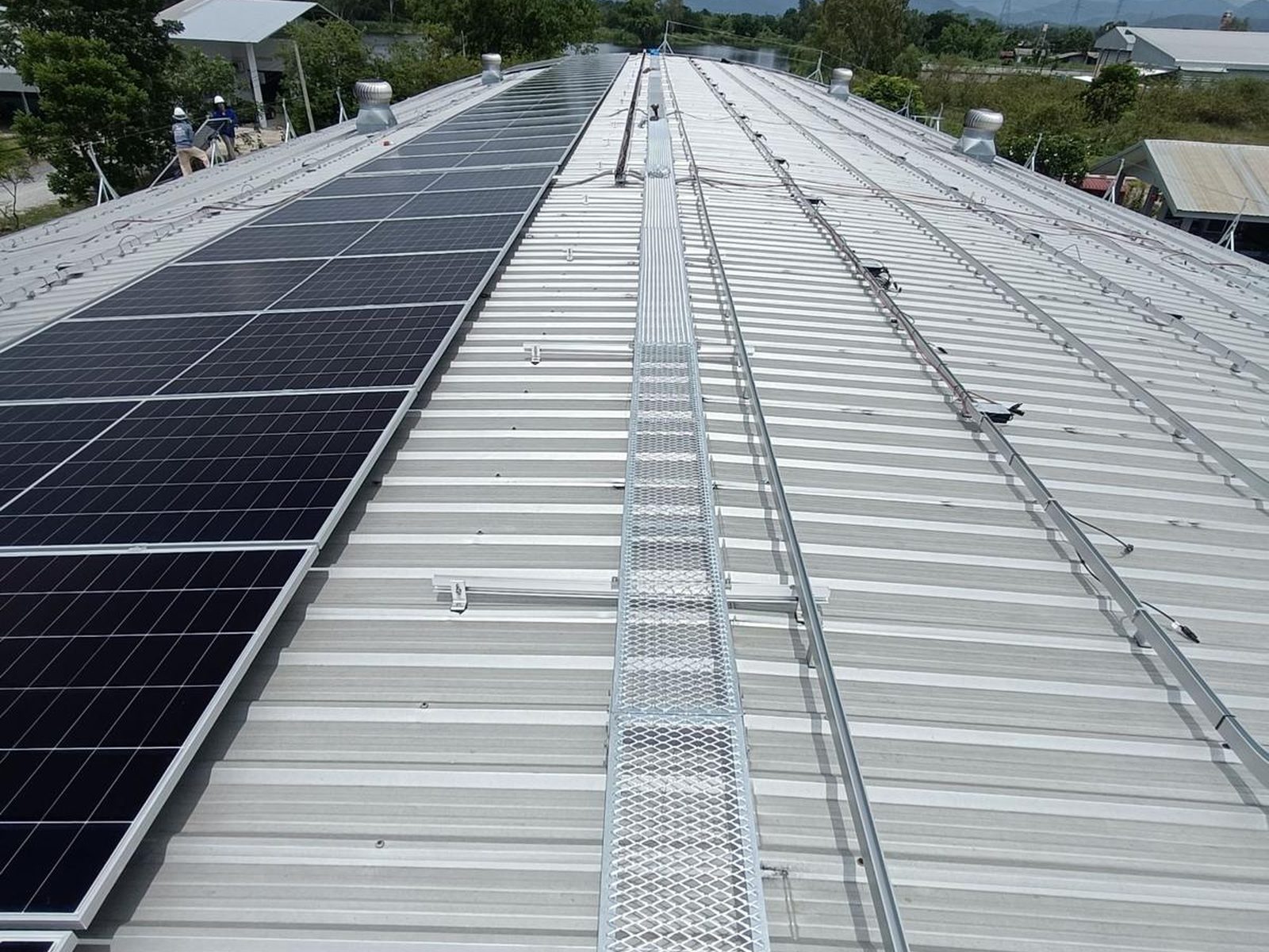 Rows of installed solar panels running the length of the factory roof